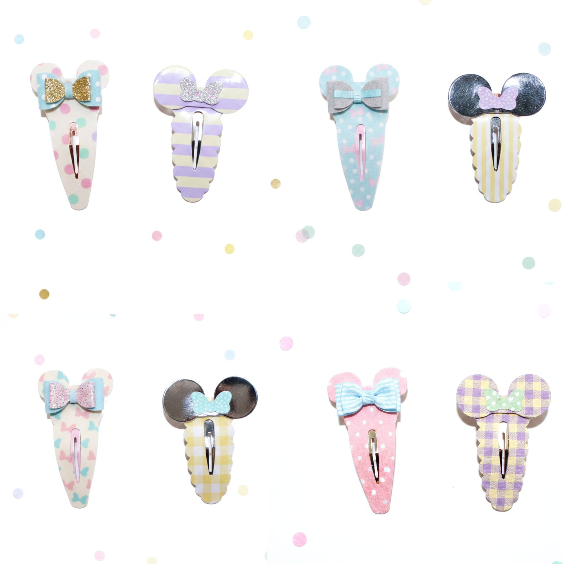 Eight pastel hair claw clips arranged in two rows on a white background with scattered pastel confetti dots. The clips feature Mouse-inspired round ears and bow details in various pastel patterns including stripes, polka dots, and gingham, with some metallic silver accents.