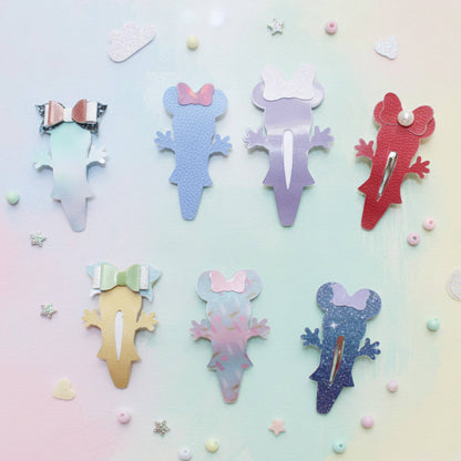 Six colorful mouse hair clips arranged on a pastel gradient background with small decorative stars and pearls. The clips have a textured aloe shape with bow details in various pastel colors including mint green, light blue, lavender, coral red, gold, pink, and dark blue.