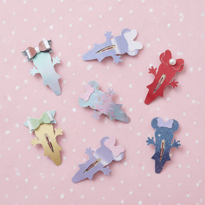 Six mouse-shaped hair clips in various pastel and glitter colors, arranged on a pink polka-dot background.