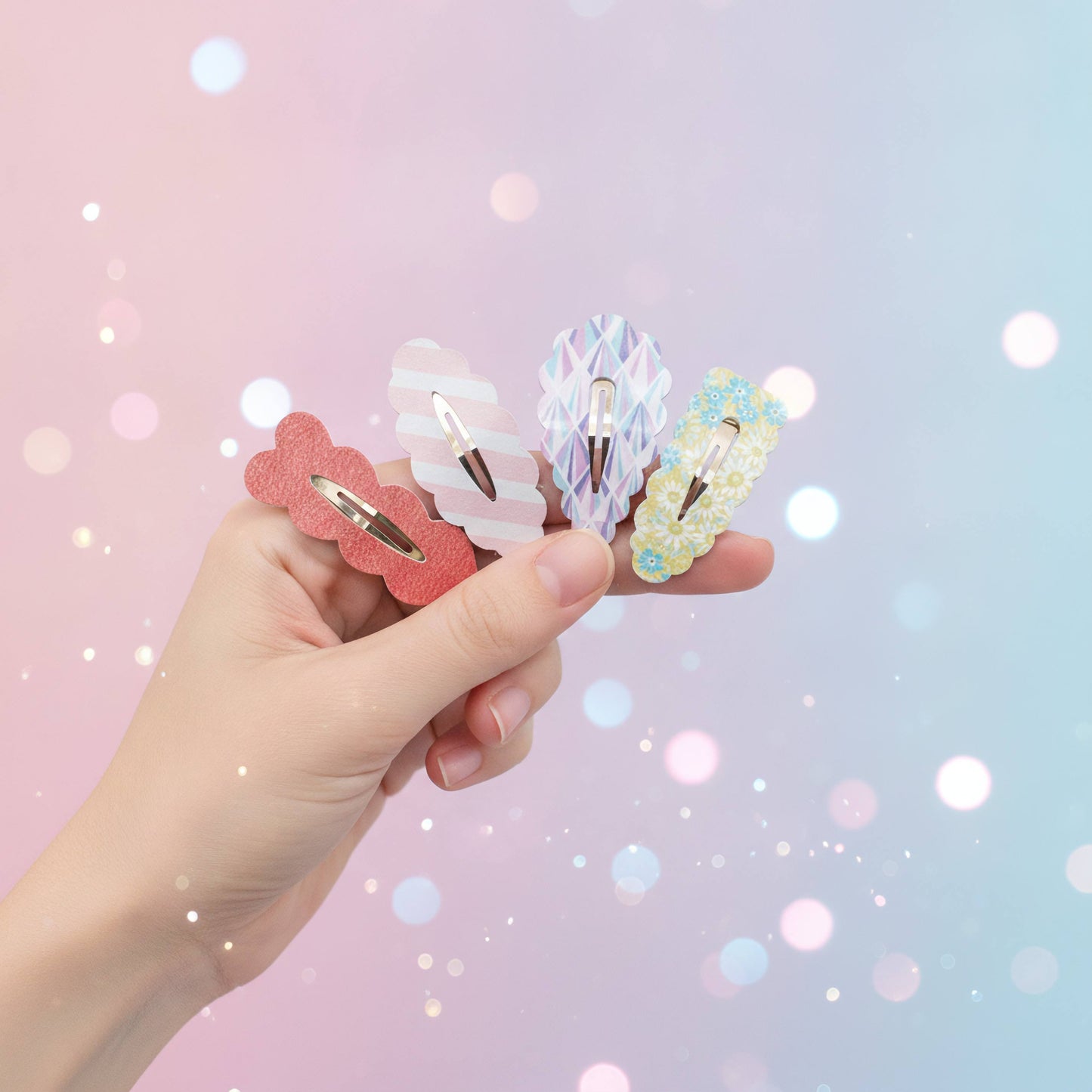 A hand holds four decorative hair clips against a soft pastel background with glowing bokeh lights. The clips include a coral pink scalloped clip, a white wavy clip with iridescent details, a lavender iridescent clip, and a pale yellow floral clip.