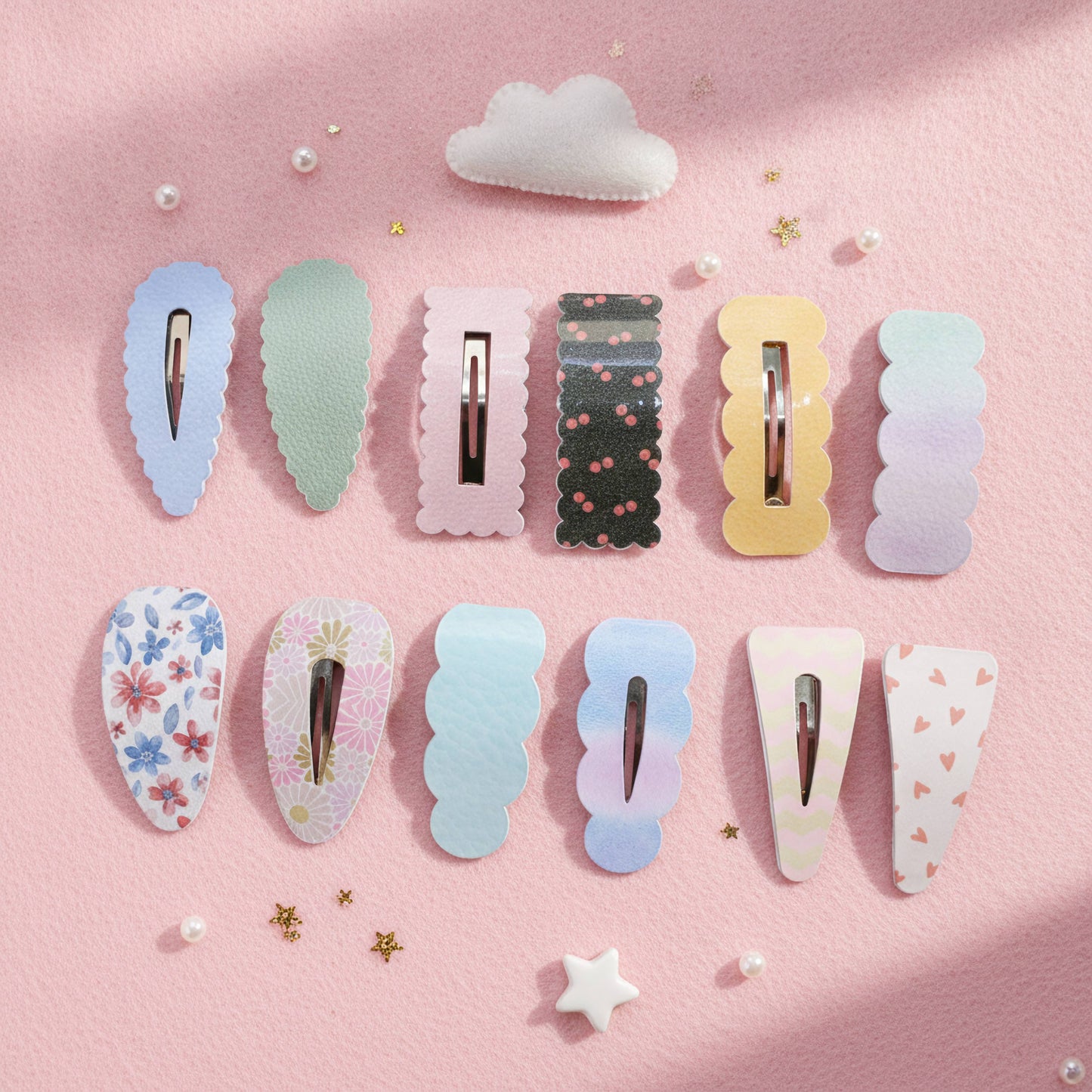 A set of pastel hair claw clips arranged in two rows on a pink background with small decorative stars, pearls, and a cloud. The clips feature various designs including solid pastel colors, floral prints, and gradients.