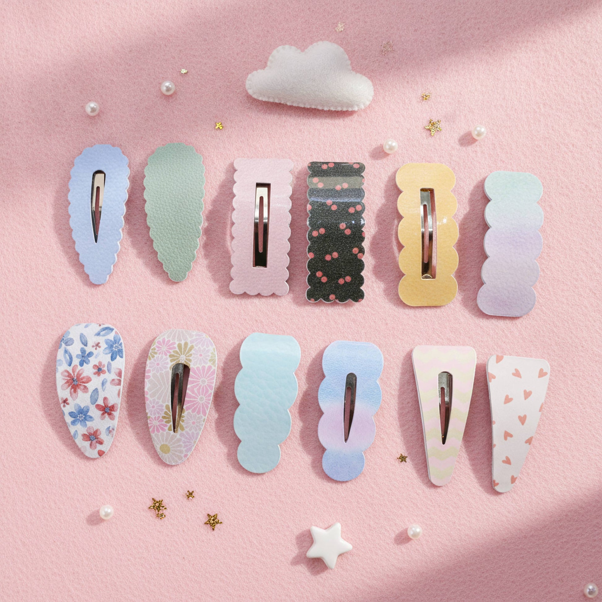 A set of pastel hair claw clips arranged in two rows on a pink background with small decorative stars, pearls, and a cloud. The clips feature various designs including solid pastel colors, floral prints, and gradients.