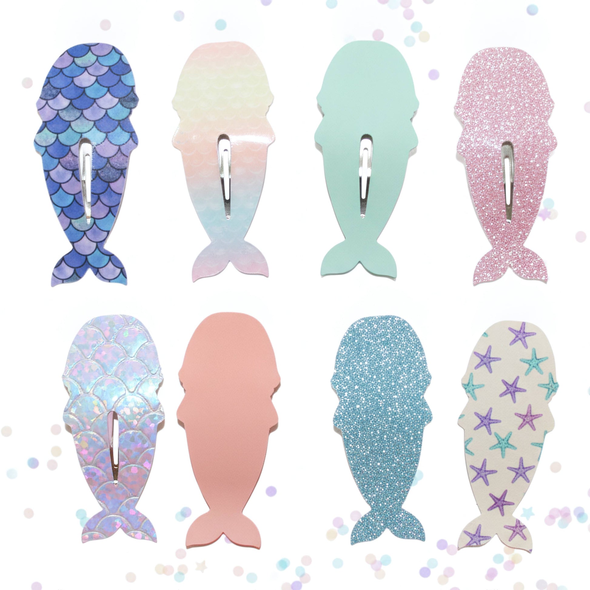 Six mermaid tail hair clips arranged in two rows on a white background with subtle pastel confetti dots. The clips feature various designs including blue and purple scales, a pastel gradient, mint green, pink glitter, iridescent scales, solid pink, blue glitter, and white with purple star patterns.
