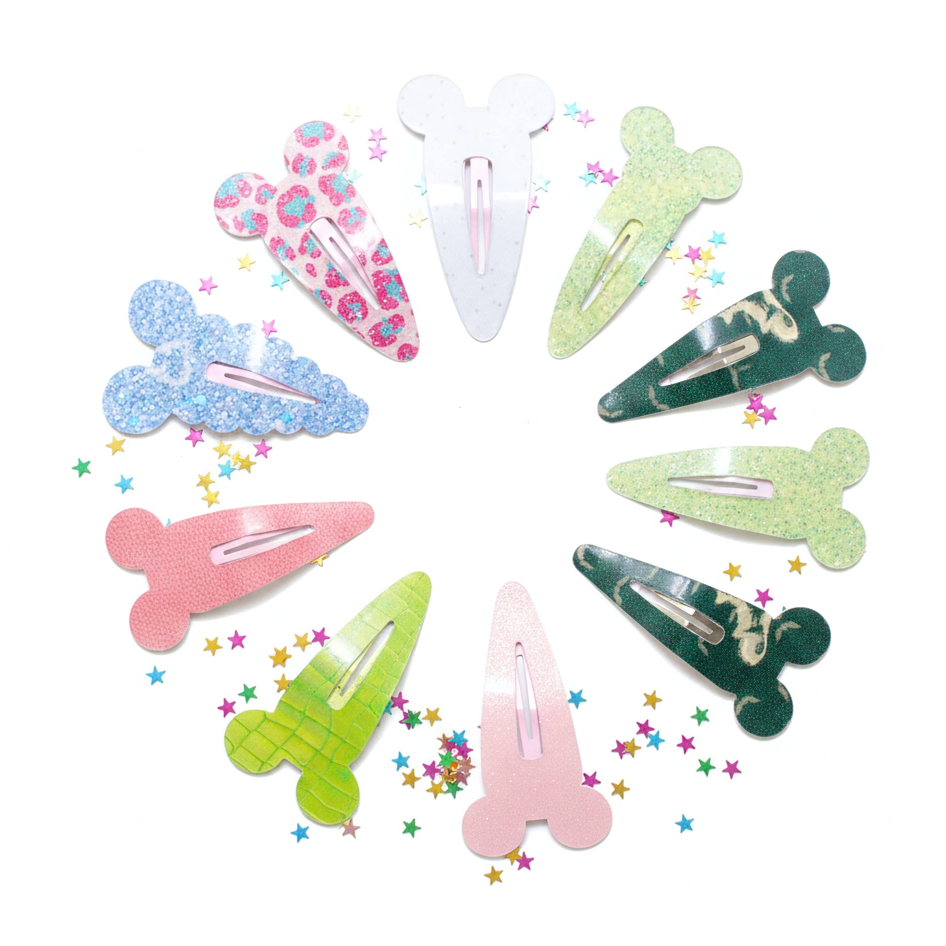 A set of eight cartoon mouse ears hair clips arranged in a circle on a white background, featuring various colors, patterns, and shapes including glitter, floral, and solid designs.