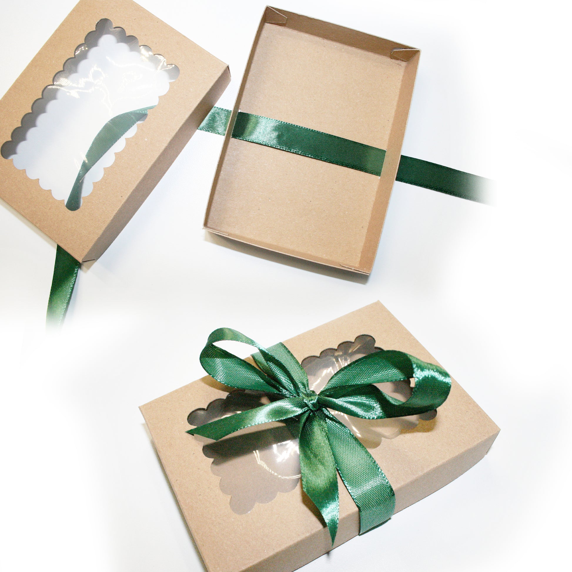 Three brown gift boxes with green ribbons on a white background