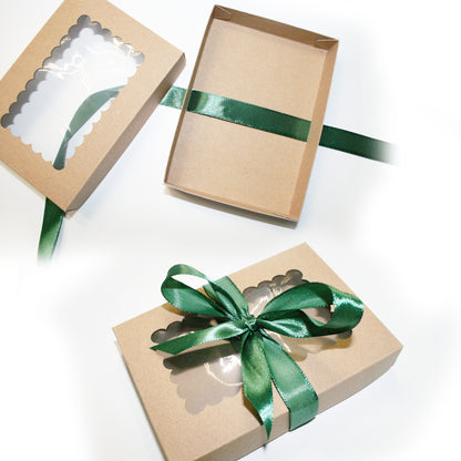 Three brown gift boxes with green ribbons on a white background